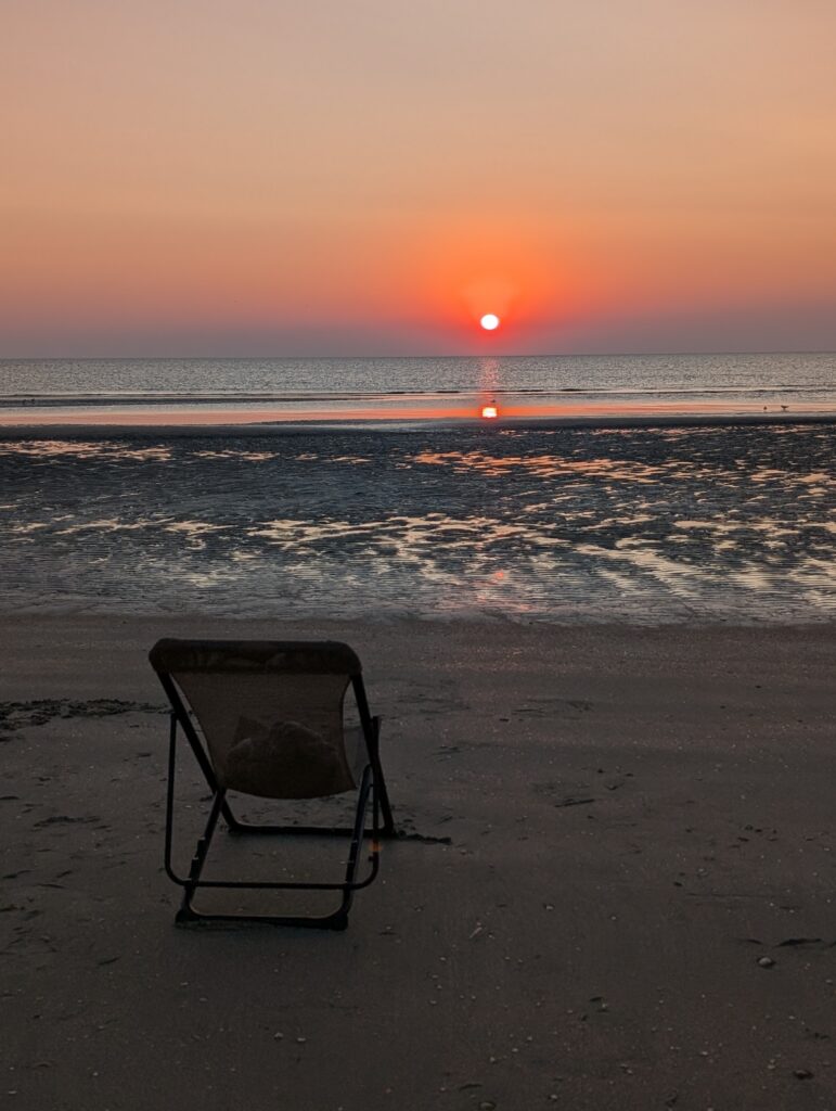Sonnenuntergang am Strand auf Röm in Lakolk mit Strandstuhl Was kann man auf Römö machen?